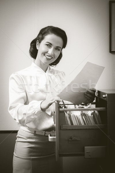 Glimlachend secretaris zoeken bestanden kabinet vintage Stockfoto © stokkete