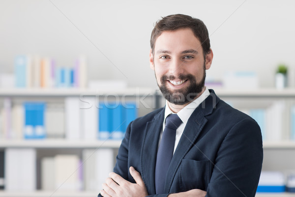 üzletember iroda fiatal pózol mosolyog kamera Stock fotó © stokkete
