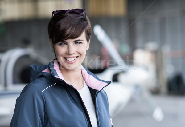 Smiling female pilot posing in the hangar Stock photo © stokkete