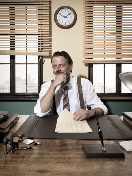 Confident businessman working at desk with hand on chin Stock photo © stokkete