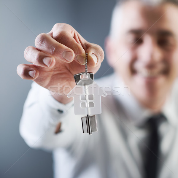Real estate agent holding out house keys Stock photo © stokkete