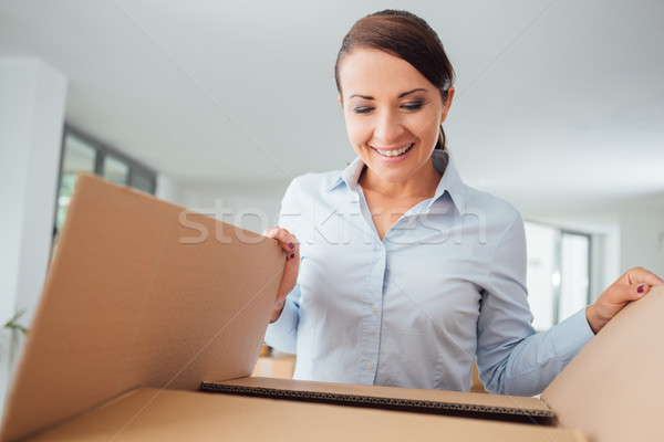 Happy woman unpacking Stock photo © stokkete