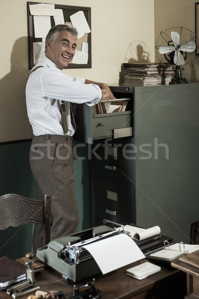 Glimlachend kantoormedewerker zoeken bestand vrolijk werknemer Stockfoto © stokkete