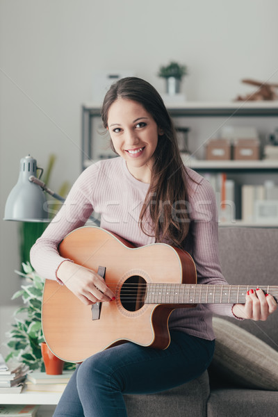 Stock photo: Girl playing guitar at home