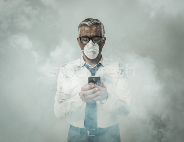 Businessman having a phone call and toxic smog Stock photo © stokkete