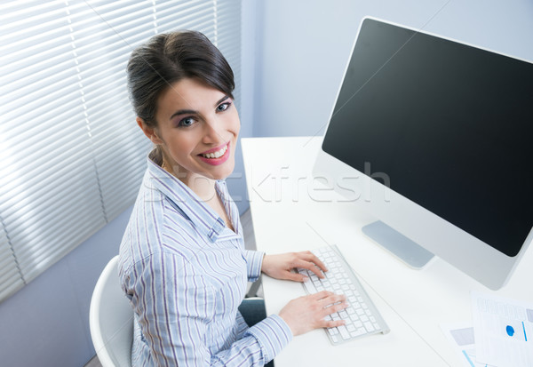 Cute businesswoman smiling at desk Stock photo © stokkete