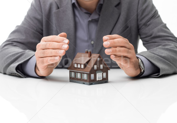 Otthonbiztosítás tervek üzletember modell ház kezek Stock fotó © stokkete