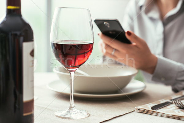 Femeie smartphone restaurant potabilă vin rosu amenda de mese Imagine de stoc © stokkete