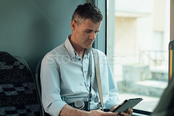Man using a digital tablet on a bus Stock photo © stokkete