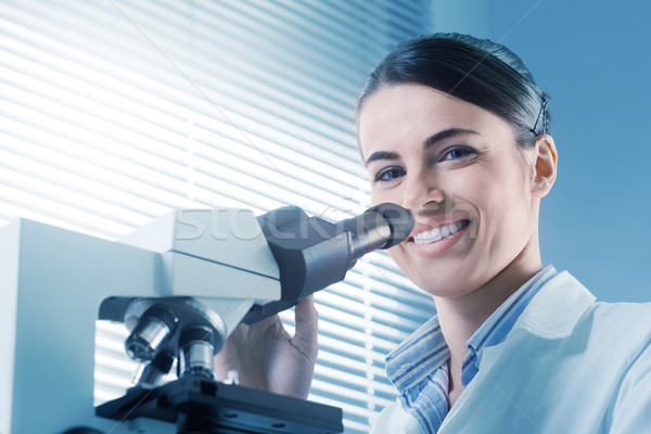 Female researcher working with microscope Stock photo © stokkete