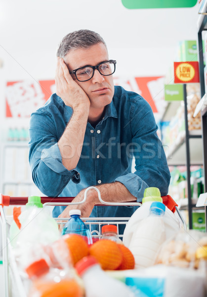 Sad man shopping at the supermarket Stock photo © stokkete