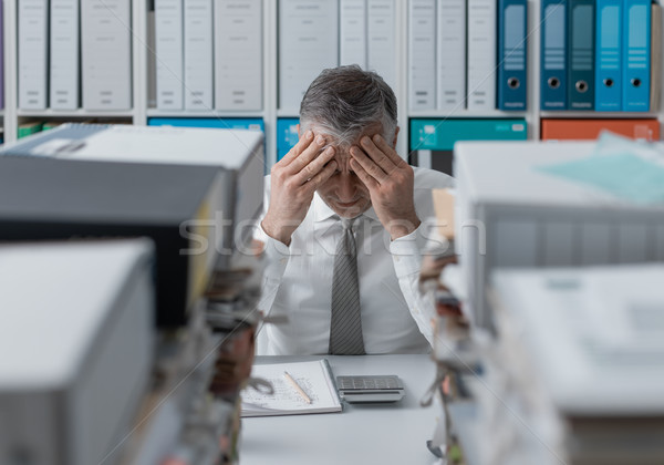 Stressed business executive and piles of paperwork Stock photo © stokkete