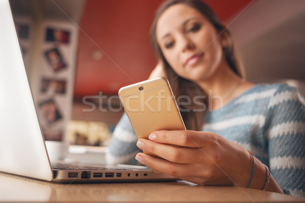 Tinilány mobiltelefon laptop sms chat dől asztal Stock fotó © stokkete