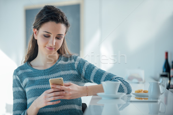 Lány mobiltelefon ül bár pult fiatal Stock fotó © stokkete