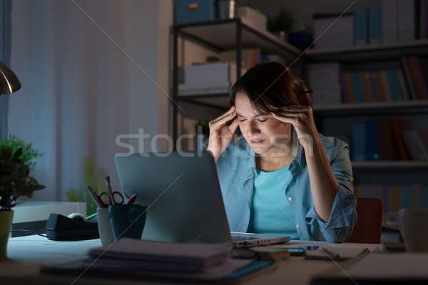 Mulher dor de cabeça tarde noite mulher jovem trabalhando Foto stock © stokkete