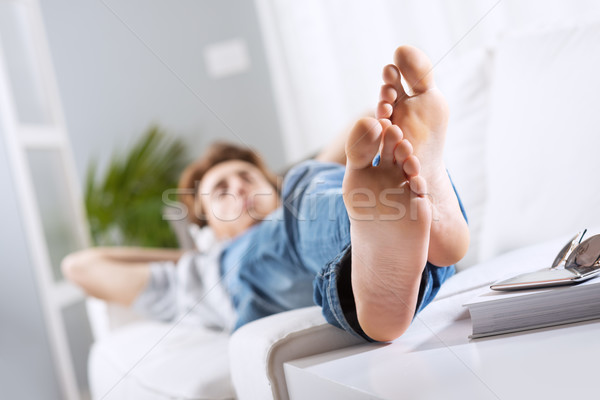 расслабляющая босиком молодым человеком диван гостиной ног Сток-фото © stokkete