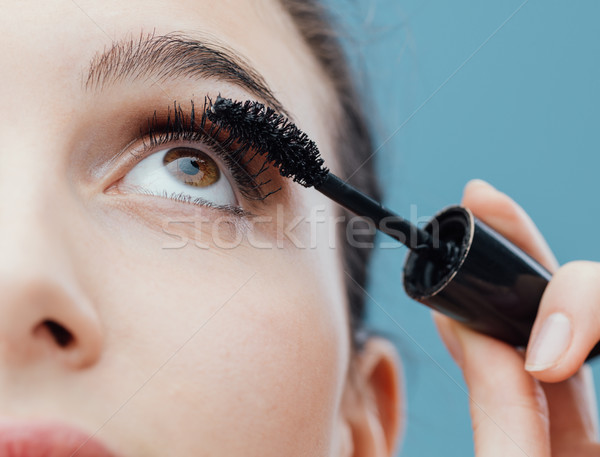 Stock photo: Woman applying mascara on her lashes