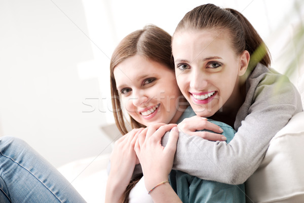 Girlfriends hugging on sofa Stock photo © stokkete