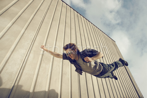 Tânăr ca superhero care zboară gratuit blugi Imagine de stoc © stokkete