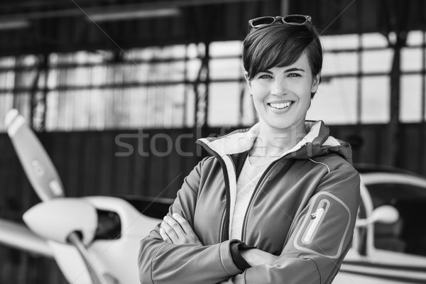 Smiling female pilot posing with her plane Stock photo © stokkete