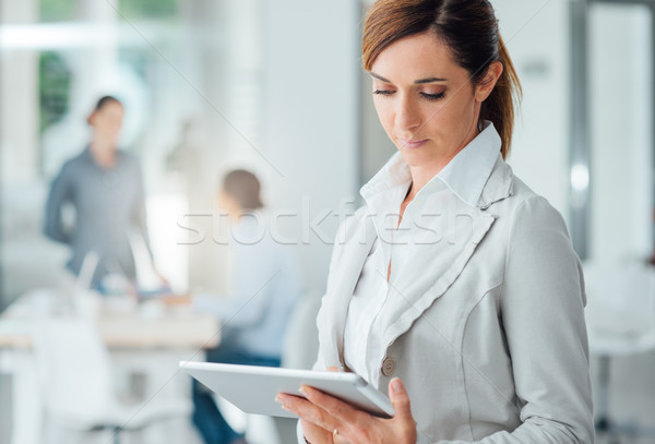 Professional business woman using a digital tablet Stock photo © stokkete