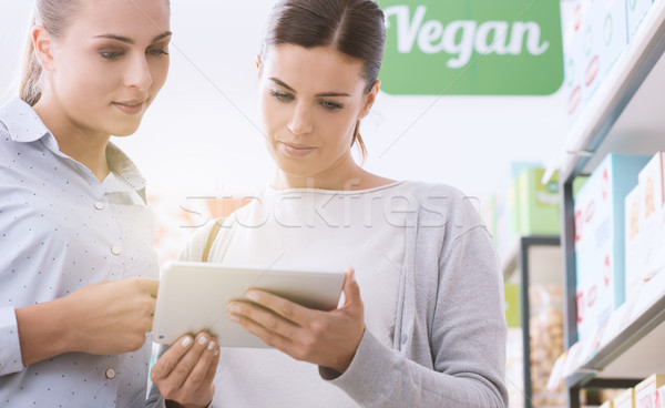 Veganistisch winkelen jonge vrouwen producten supermarkt zoeken Stockfoto © stokkete