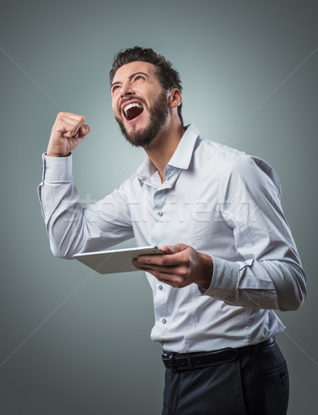 Heiter lächelnd junger Mann Tablet Mann gute Nachrichten Stock foto © stokkete
