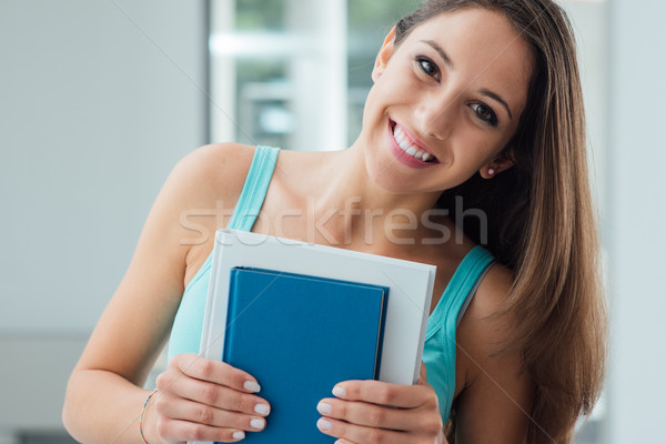 Sonriendo estudiante libros mirando Foto stock © stokkete