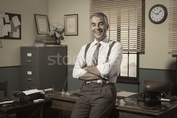 Om de afaceri birou zâmbitor cu bratele incrucisate 1950 stil Imagine de stoc © stokkete