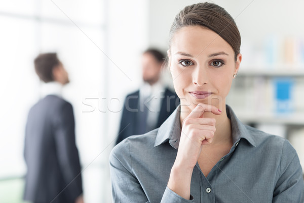Confident businesswoman with hand on chin Stock photo © stokkete