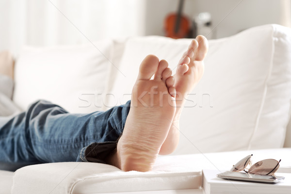 расслабляющая босиком молодым человеком диван гостиной ног Сток-фото © stokkete