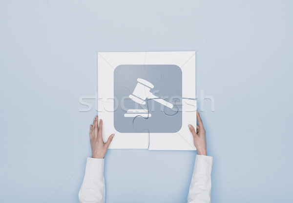 Woman completing a puzzle with a gavel icon Stock photo © stokkete