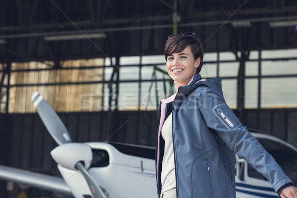Cheerful pilot posing with a small aircraft Stock photo © stokkete