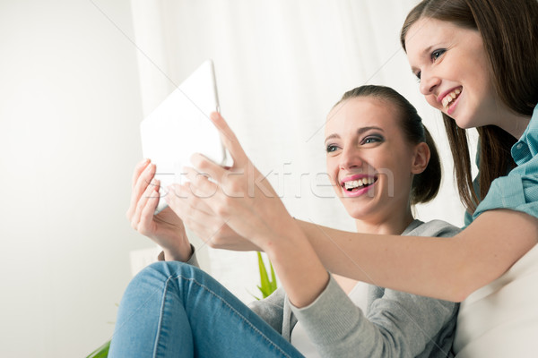 Smiling girls with tablet Stock photo © stokkete
