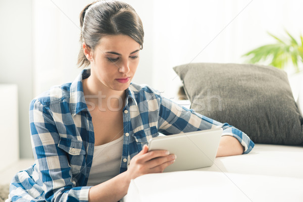 Relaxing in the living room with tablet Stock photo © stokkete