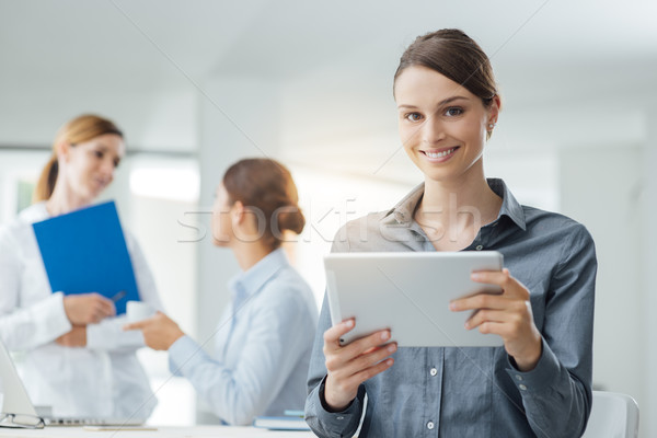 Smiling business woman using a tablet Stock photo © stokkete