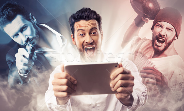 Stock photo: Cheerful man watching videos on tablet