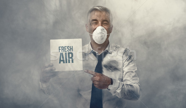 Man with pollution mask holding a sign Stock photo © stokkete