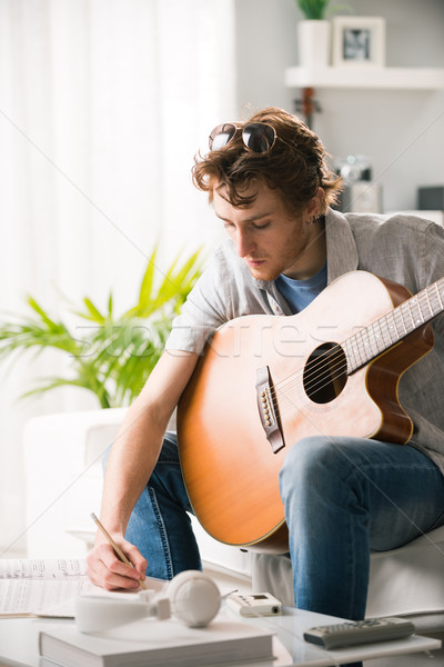 Chanson jeune homme jouer guitare séance canapé [[stock_photo]] © stokkete