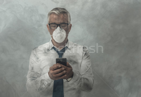 Stock photo: Businessman having a phone call and toxic smog
