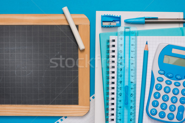 Chalkboard and stationery on blue background Stock photo © stokkete