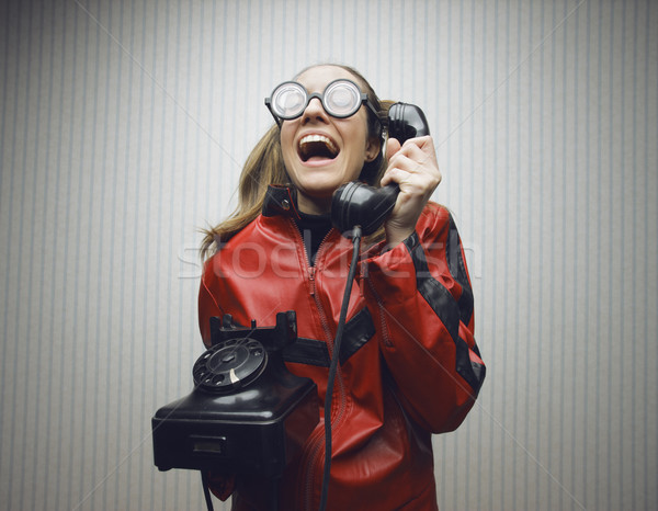Nerdy woman speaking on a black rotary vintage phone Stock photo © stokkete