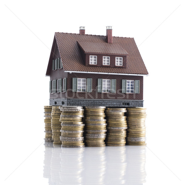 Model house with piles of coins as foundation Stock photo © stokkete