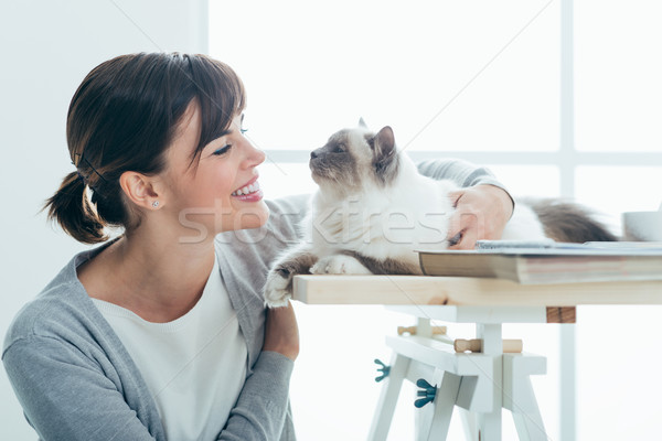 Stock photo: Happy woman cuddling her cat