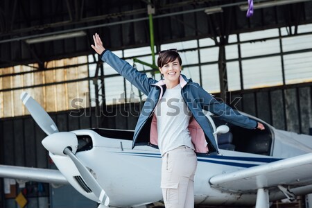 Confident female pilot posing in the hangar Stock photo © stokkete