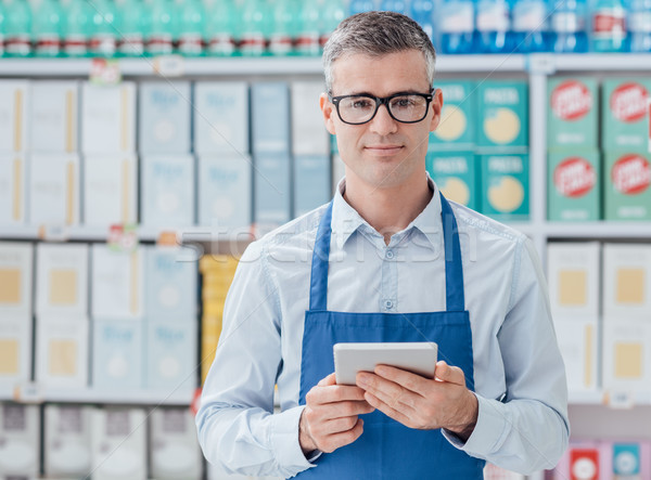 Supermarket clerk using a tablet Stock photo © stokkete