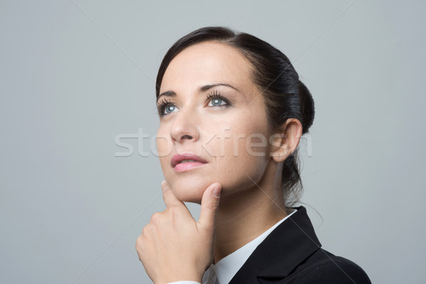 Pensive businesswoman with hand on chin Stock photo © stokkete