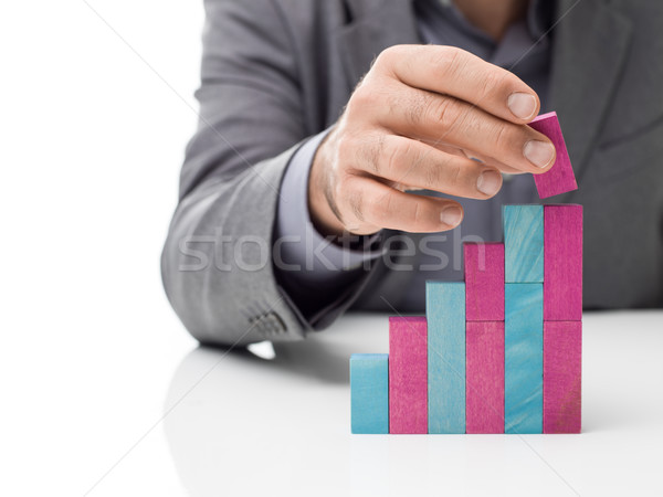 Businessman building a staircase with wood blocks Stock photo © stokkete