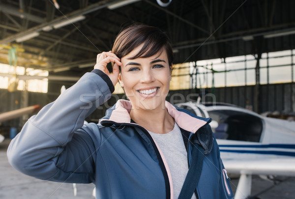 Smiling young pilot posing with a propeller plane Stock photo © stokkete