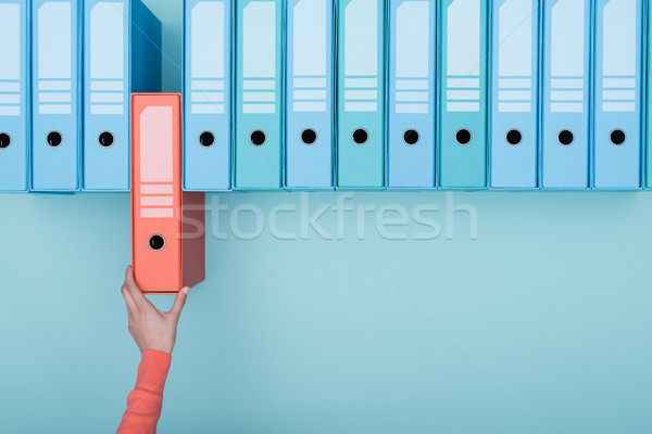 Office worker taking a folder in the archive Stock photo © stokkete
